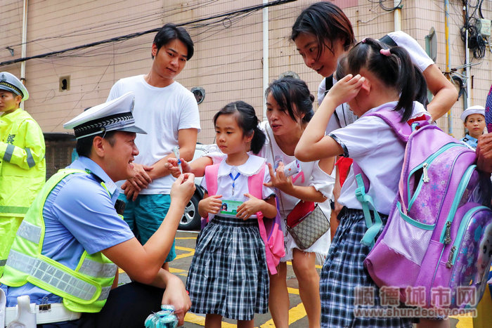 交警赠送小学生带有交通安全宣传标语的棒棒糖.jpg