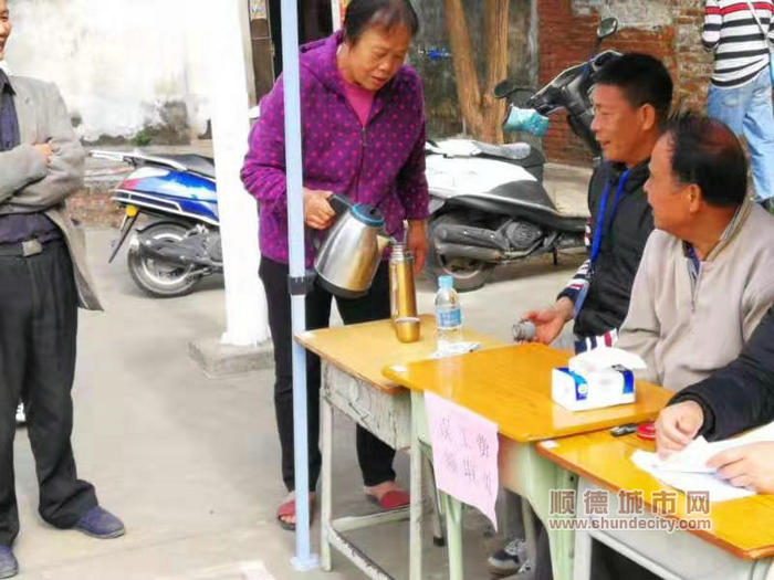 西华村村改表决现场群众为村改干部倒热茶_副本.jpg