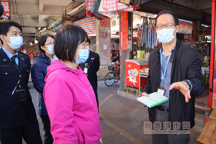 大良市监所副所长邓健钊（右）与市场管理方交流.JPG