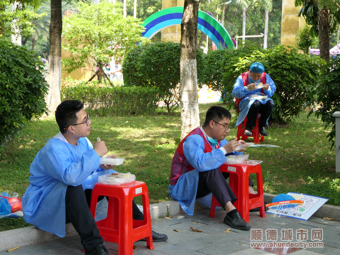 换班吃饭，志愿者们的饭桌仅是一张塑料凳。.jpg