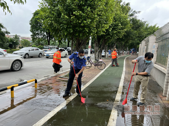 齐齐动手，扫除路面积水。.jpg