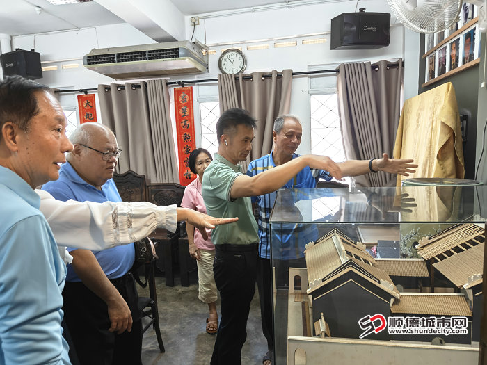 马来西亚太平顺德会馆会长卢炳华（左二）通过岐立堂模型向访问团介绍会馆旧址修复计划.jpg